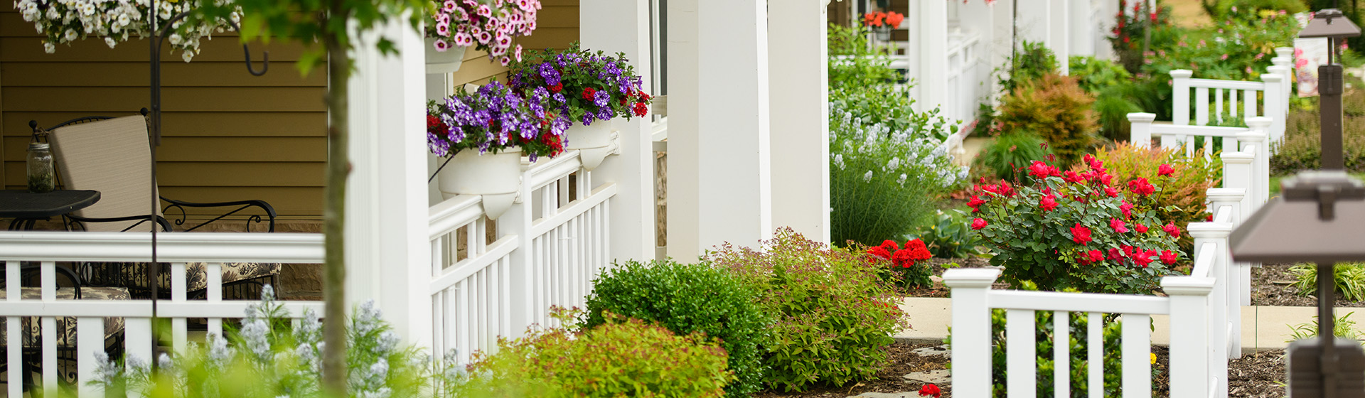 a white picket fence surrounds a lush green garden