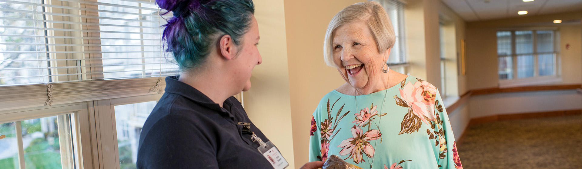 a woman with purple hair is talking to an older woman